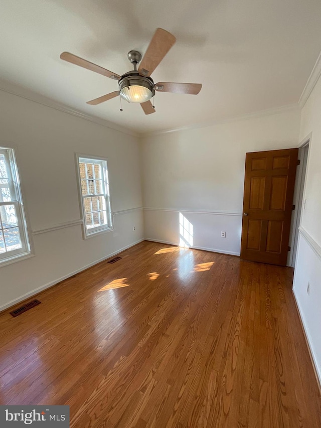 unfurnished room with wood-type flooring, ceiling fan, and ornamental molding