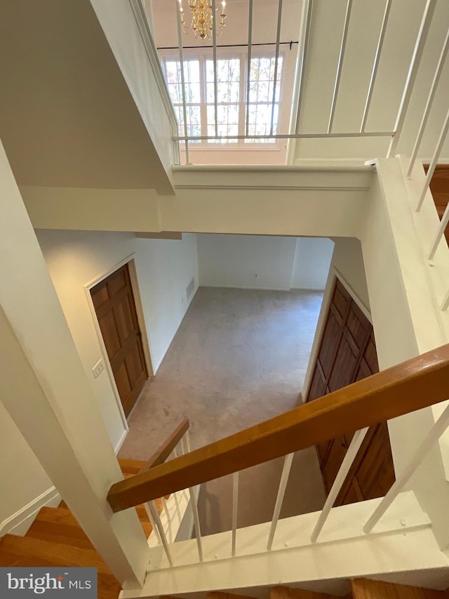 staircase featuring carpet flooring and an inviting chandelier