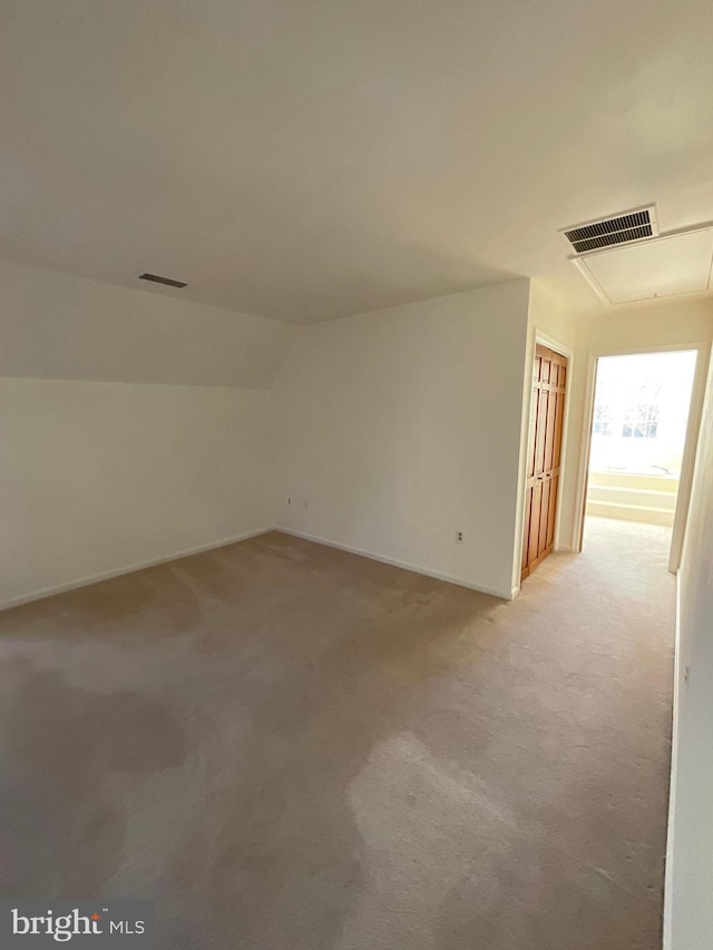 additional living space featuring light carpet