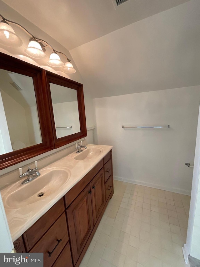 bathroom with tile patterned floors, vanity, and vaulted ceiling