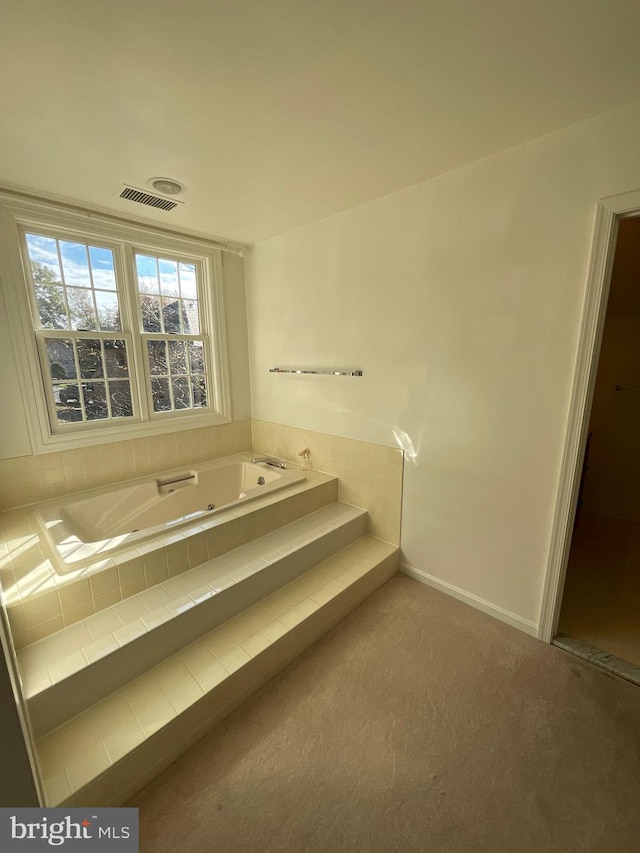 bathroom with a relaxing tiled tub