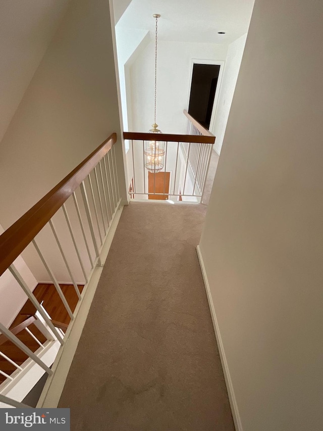 corridor with carpet flooring and a chandelier