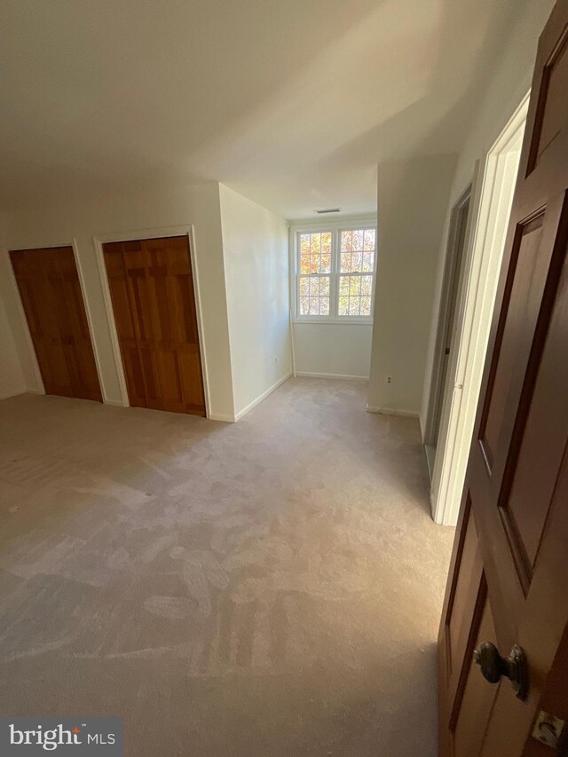 unfurnished bedroom featuring light carpet