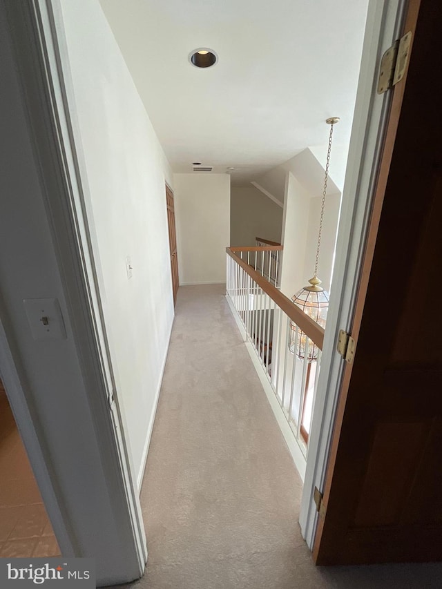 hallway featuring light colored carpet