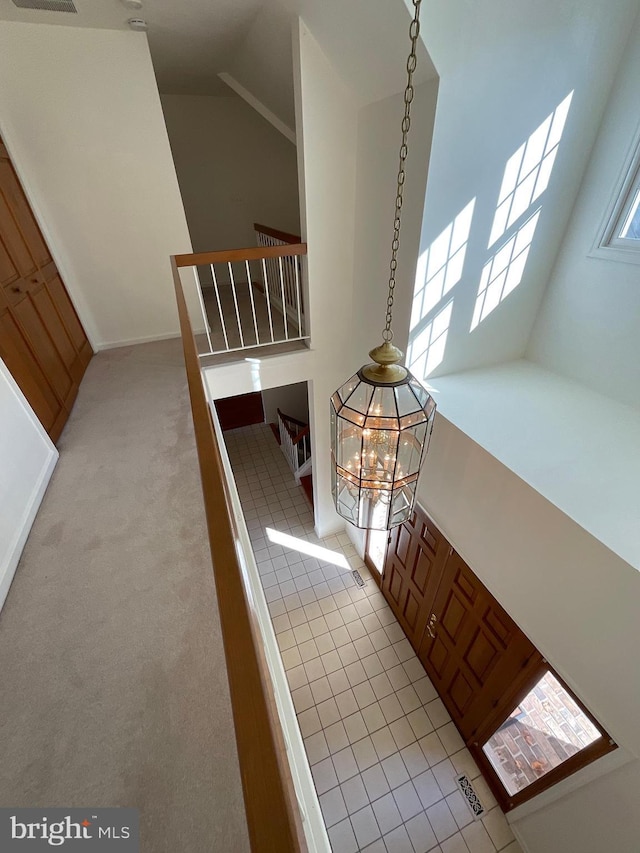 interior space with a notable chandelier, light tile patterned floors, and high vaulted ceiling