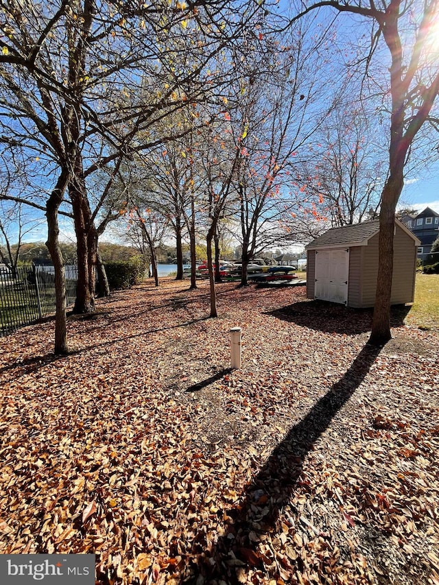 view of yard featuring a water view and a shed