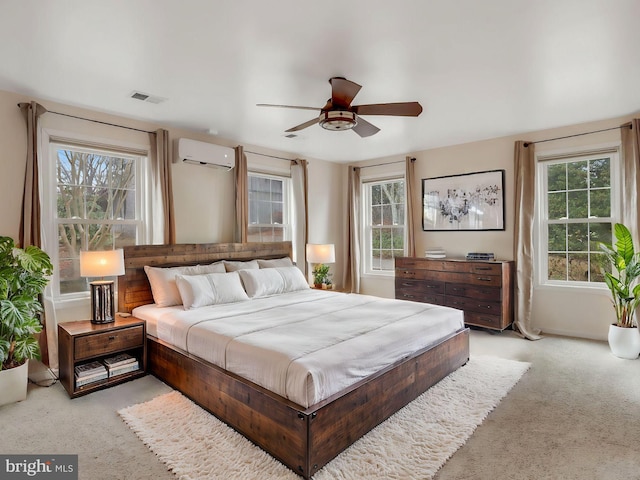 carpeted bedroom featuring a wall mounted AC and ceiling fan