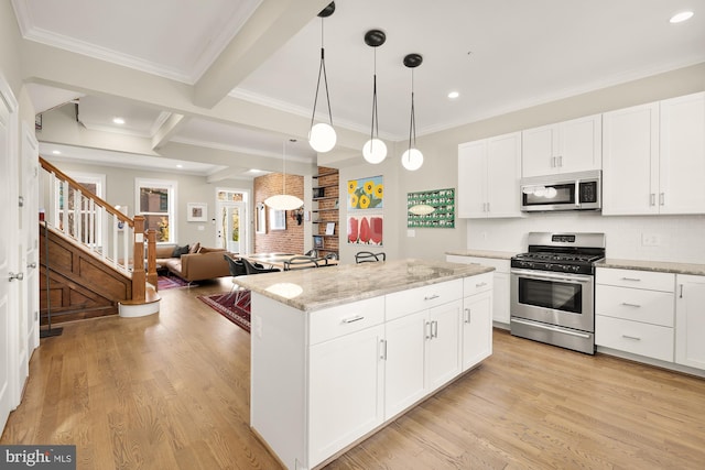 kitchen featuring stainless steel appliances, beam ceiling, light wood-style flooring, and a center island