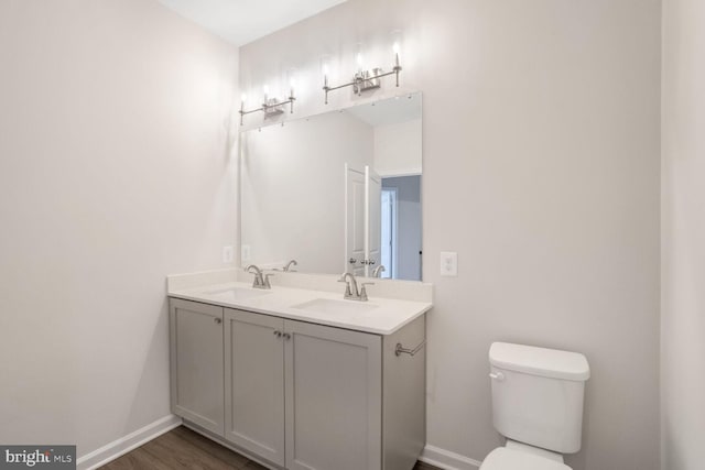 bathroom featuring vanity, wood-type flooring, and toilet