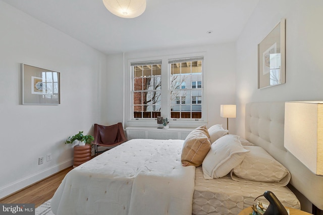 bedroom with radiator heating unit and hardwood / wood-style floors