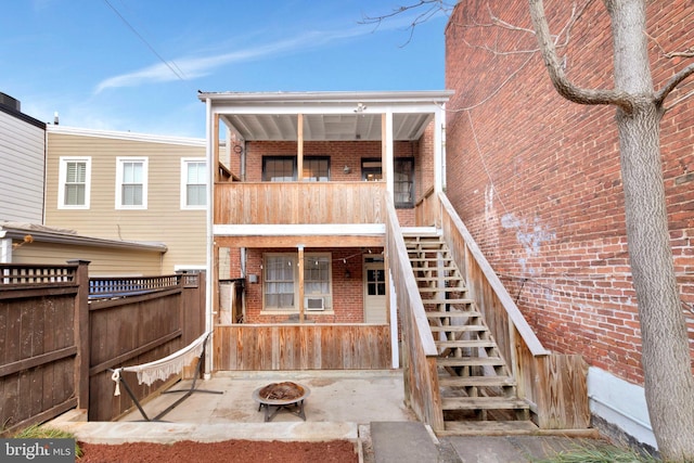 rear view of property featuring a fire pit