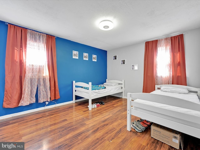 bedroom featuring hardwood / wood-style flooring and multiple windows