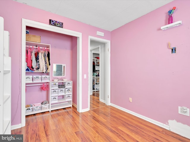 bedroom with hardwood / wood-style floors and a closet