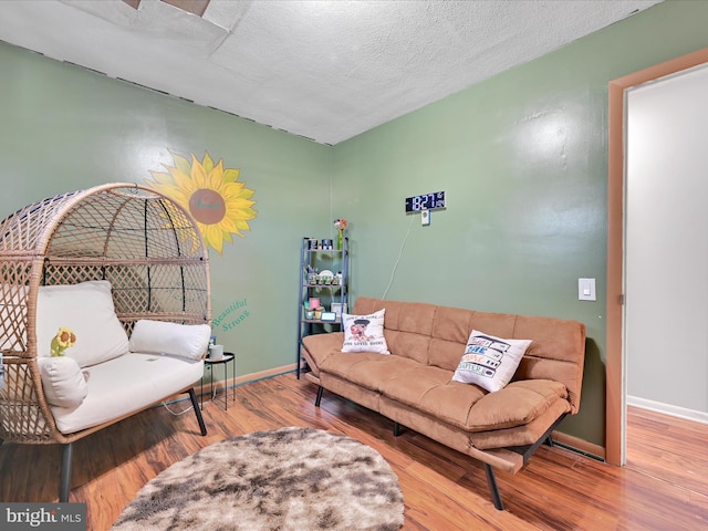 living room with wood-type flooring and a textured ceiling