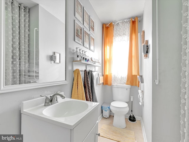 bathroom featuring tile patterned floors, vanity, and toilet