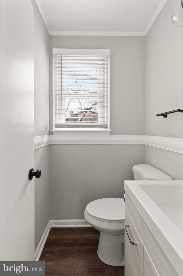 bathroom with toilet, vanity, ornamental molding, and hardwood / wood-style flooring