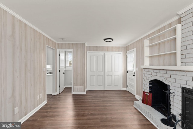 unfurnished living room featuring a fireplace, ornamental molding, and dark wood-type flooring