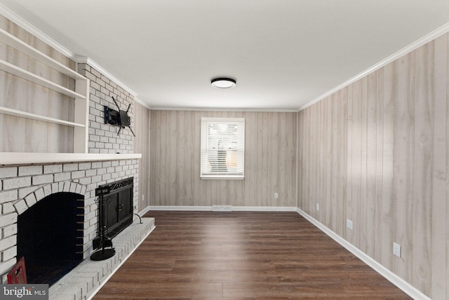 unfurnished living room featuring a fireplace, dark hardwood / wood-style flooring, crown molding, and wood walls