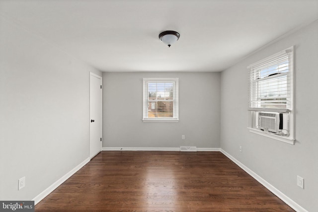 spare room with cooling unit and dark wood-type flooring