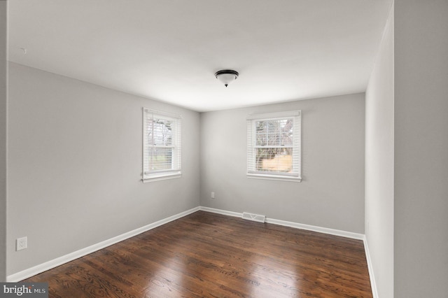 spare room with dark hardwood / wood-style flooring