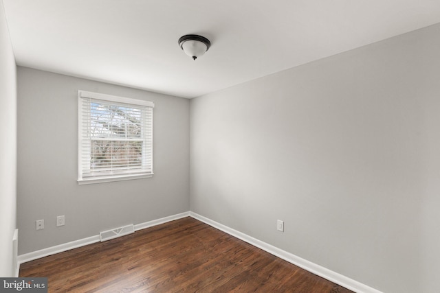 spare room with dark wood-type flooring