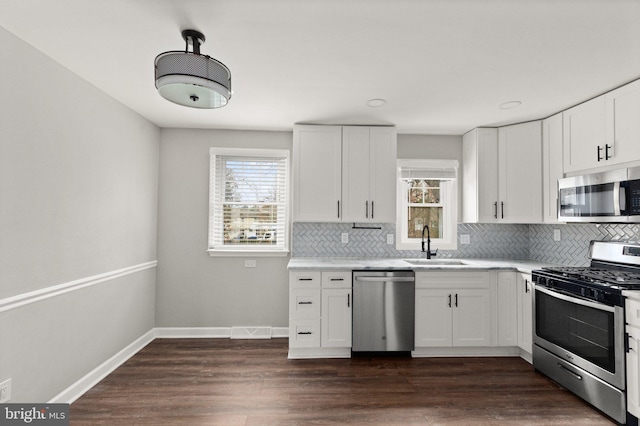 kitchen with a wealth of natural light, white cabinetry, and appliances with stainless steel finishes