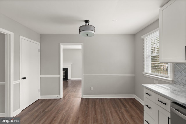 unfurnished dining area with dark wood-type flooring