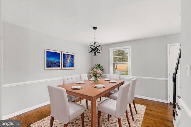 dining room with dark hardwood / wood-style flooring and a notable chandelier