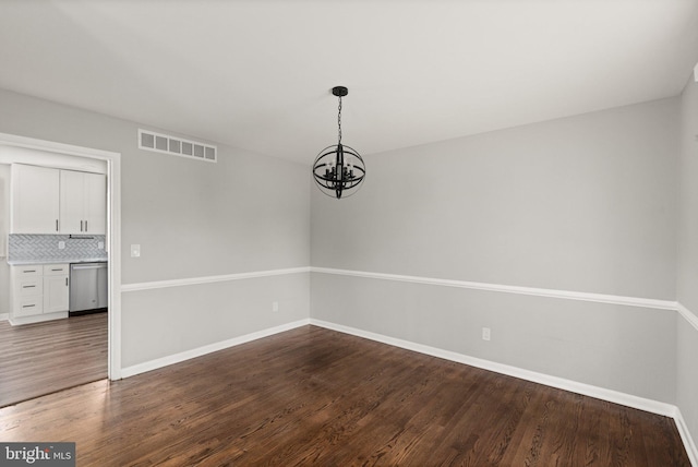 unfurnished dining area with wood-type flooring and a chandelier