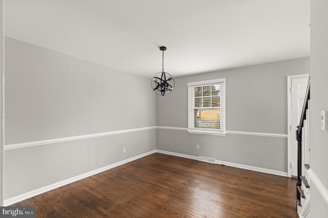 unfurnished dining area with dark wood-type flooring and a chandelier