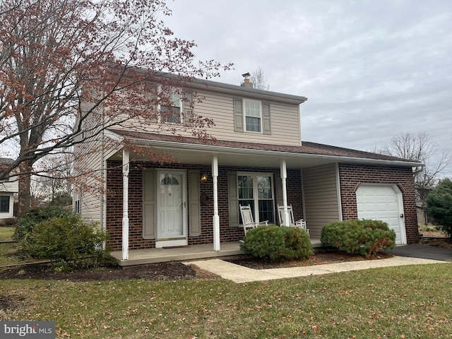 view of front property featuring a front lawn, covered porch, and a garage