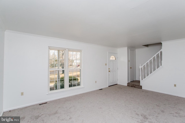 unfurnished living room with light colored carpet and ornamental molding