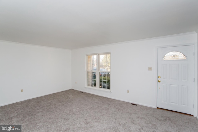 entryway with crown molding and light colored carpet