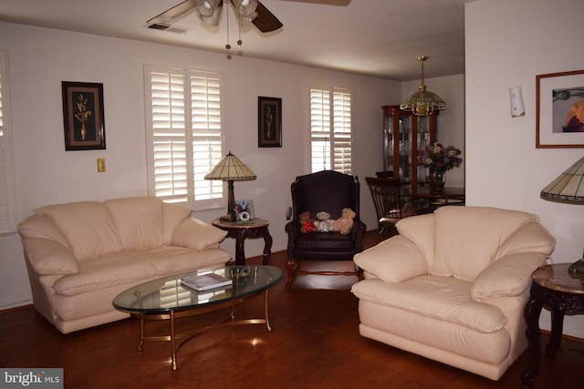 living room featuring ceiling fan with notable chandelier and dark hardwood / wood-style floors