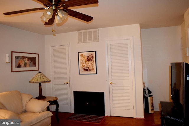 living room with ceiling fan and dark hardwood / wood-style floors