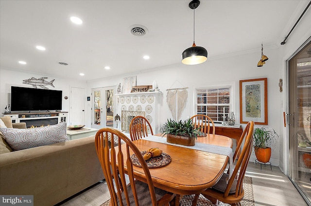 dining space featuring light hardwood / wood-style flooring and ornamental molding