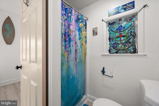 bathroom featuring a shower with shower curtain, toilet, and wood-type flooring