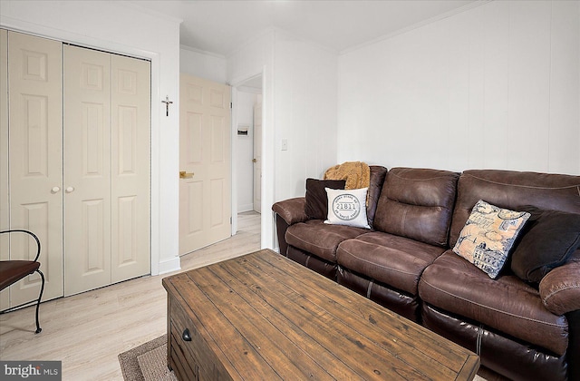 living room with crown molding and light wood-type flooring