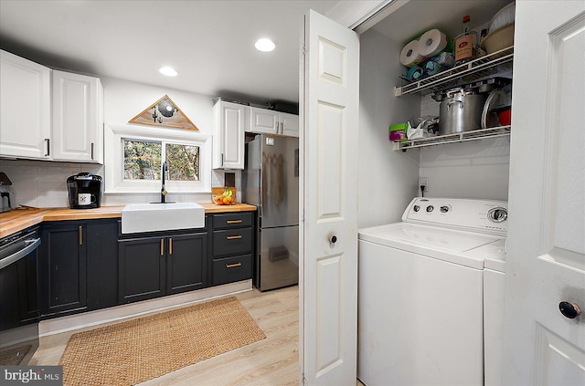 washroom featuring washer / dryer, light hardwood / wood-style flooring, and sink