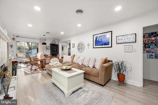 living room with crown molding and light hardwood / wood-style flooring