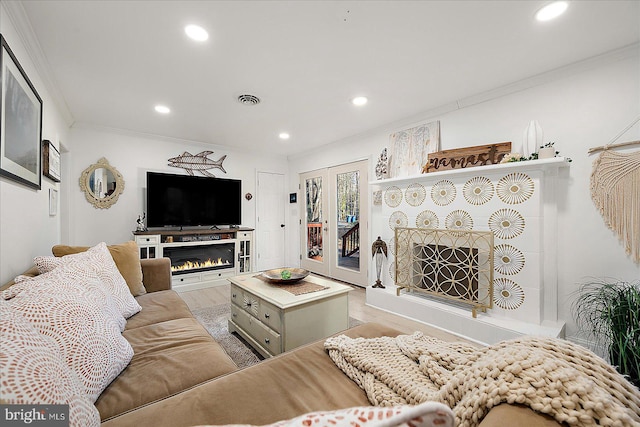 living room with light wood-type flooring and ornamental molding