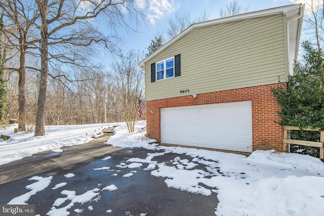 view of snow covered exterior with a garage