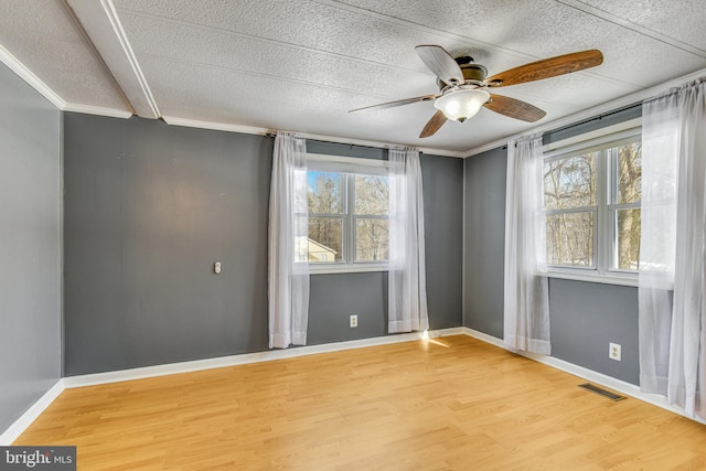 spare room with hardwood / wood-style floors, ceiling fan, and crown molding