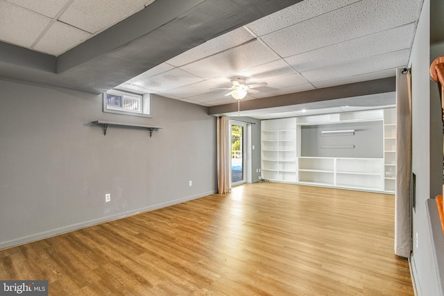 interior space with a drop ceiling, light hardwood / wood-style floors, and ceiling fan