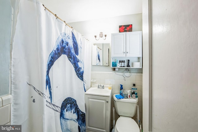 bathroom featuring a shower with curtain, vanity, toilet, and tile walls