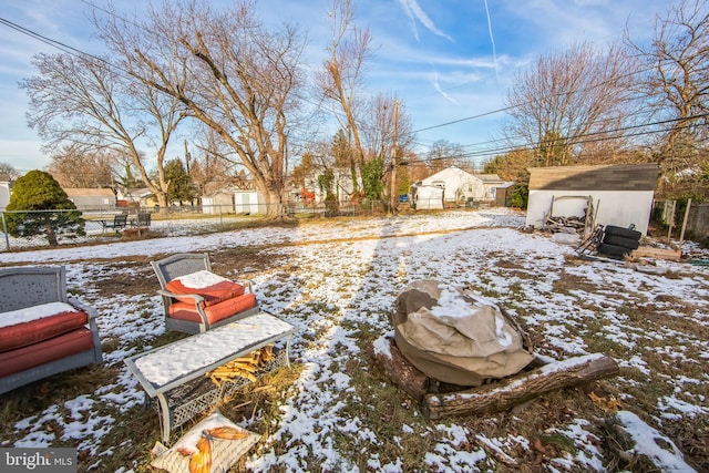 snowy yard featuring a storage shed