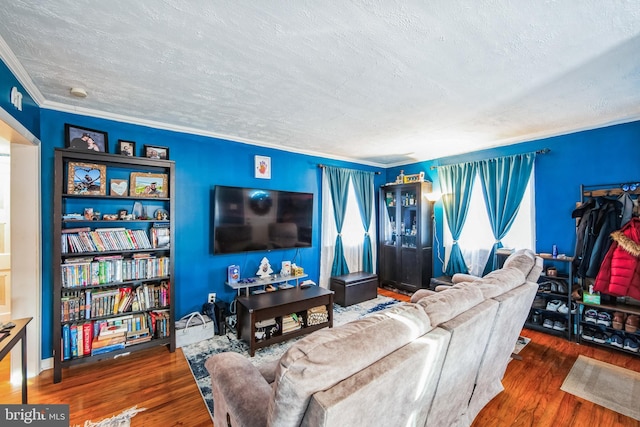 living room featuring a textured ceiling, dark hardwood / wood-style floors, and ornamental molding