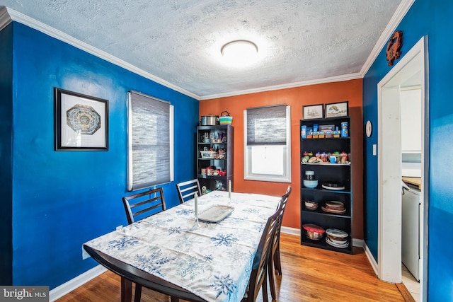 dining room featuring a textured ceiling, light hardwood / wood-style floors, and crown molding