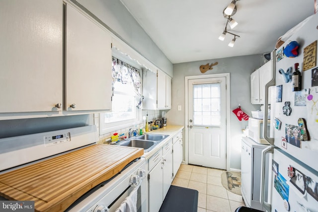 kitchen featuring white cabinets, light tile patterned floors, a wealth of natural light, and sink