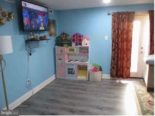 playroom featuring visible vents, baseboards, and wood finished floors